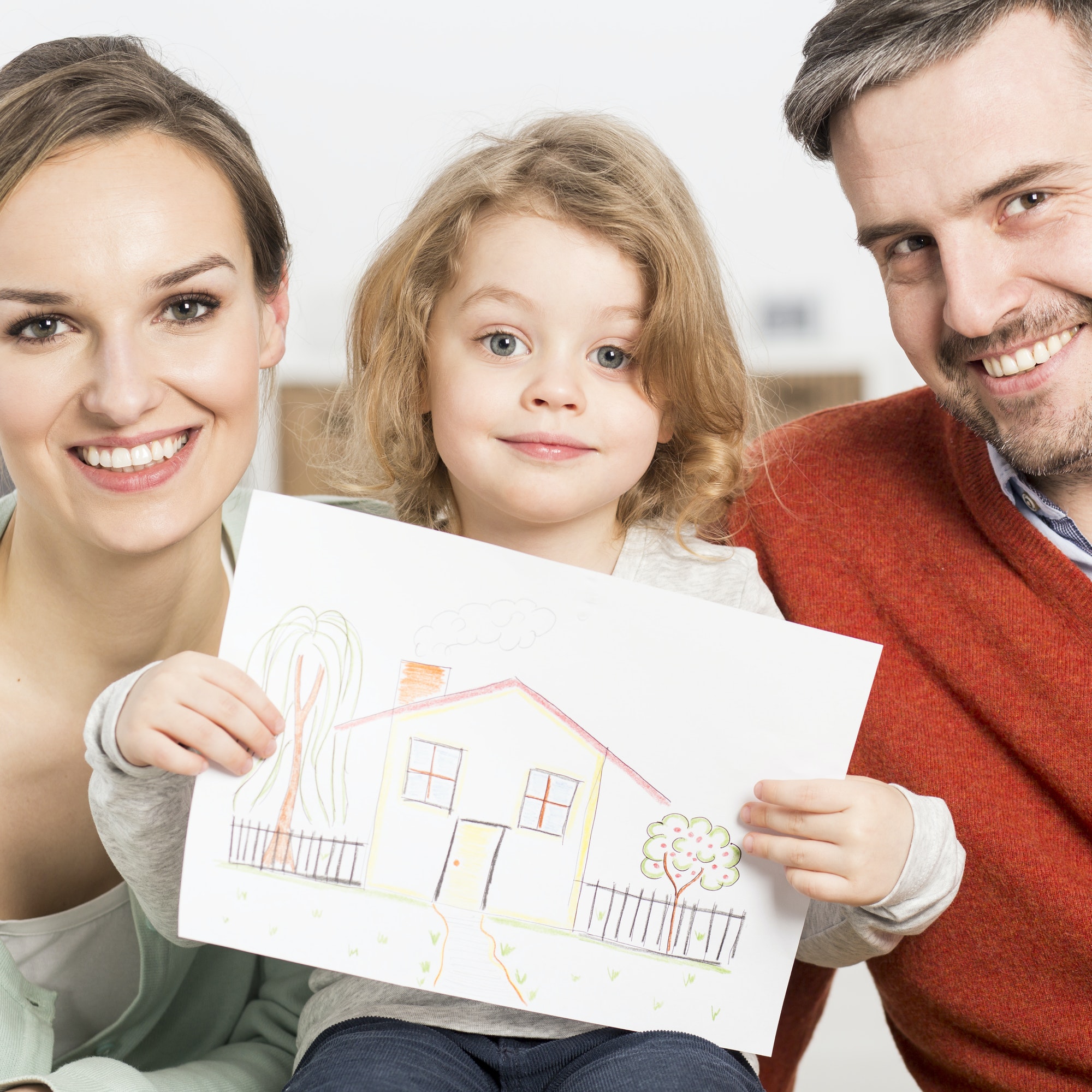 Young parents and child holding picture